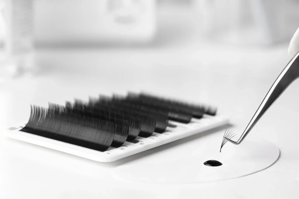 An ultra close-up of an eyelash extension set with a drop of eyelash glue.