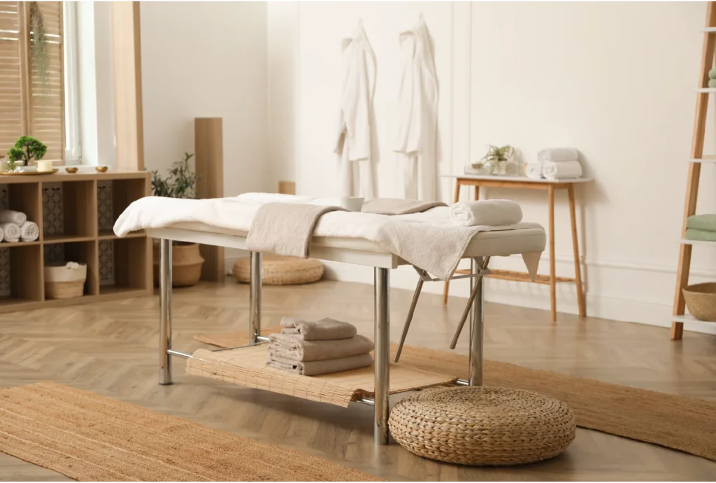 A beige massage table in a coherently designed room