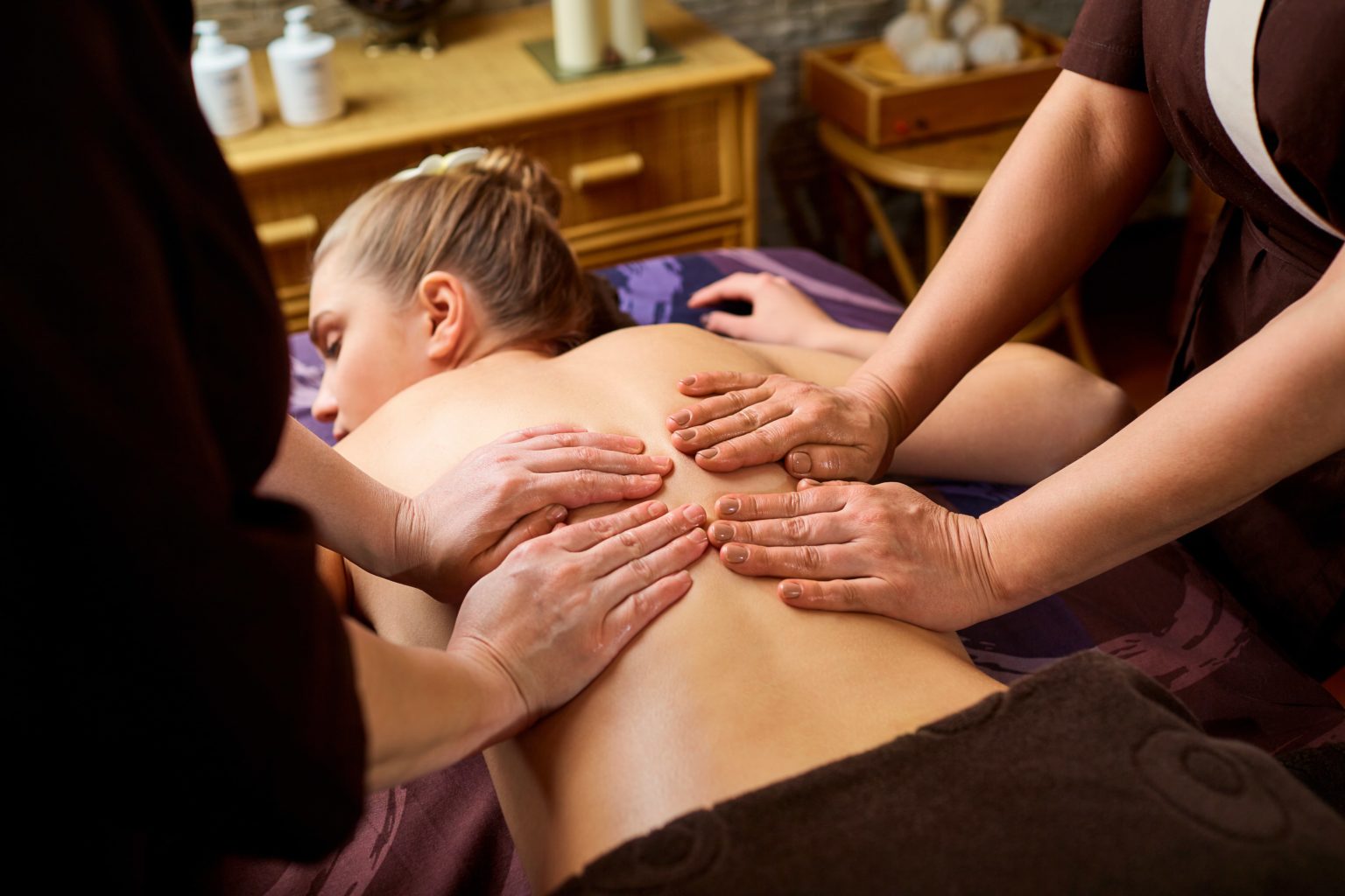 two massage therapists giving one massage