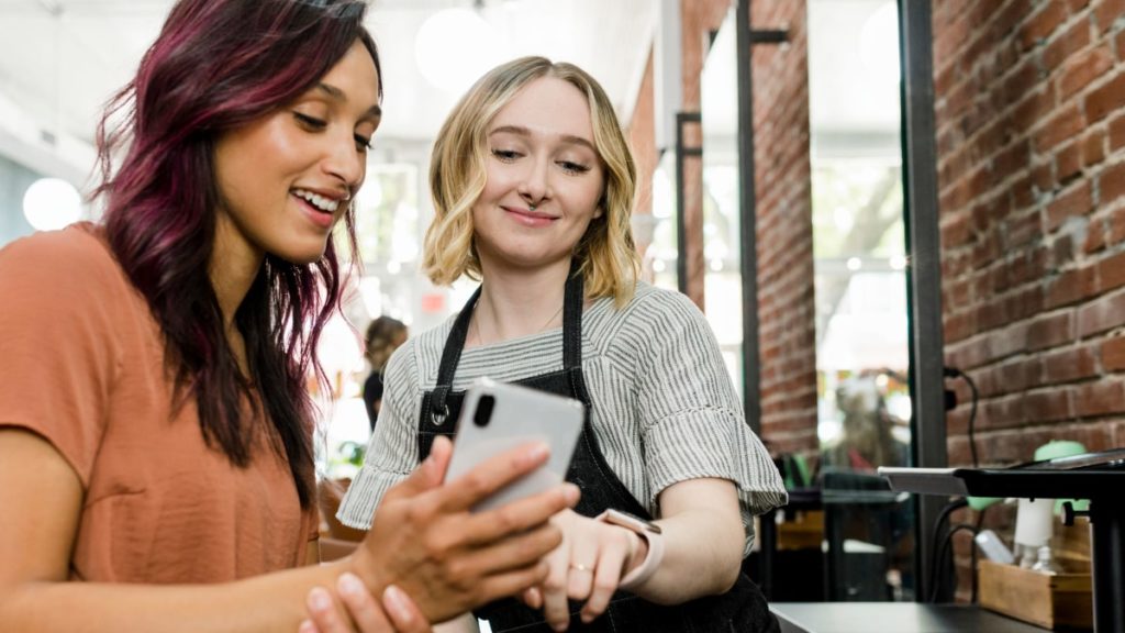 people in a salon looking at a phone