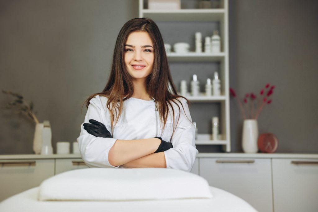 female cosmetologist folding arms looking at viewer