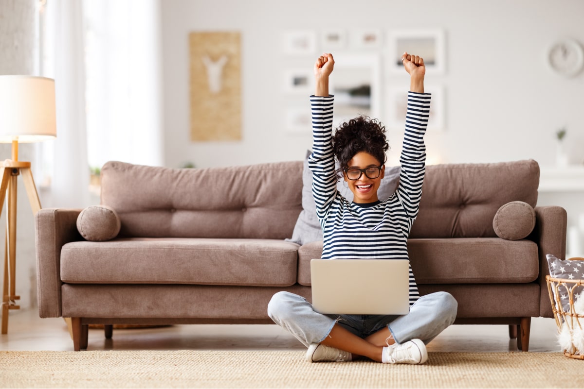 woman celebrating with hands in the air in her living room
