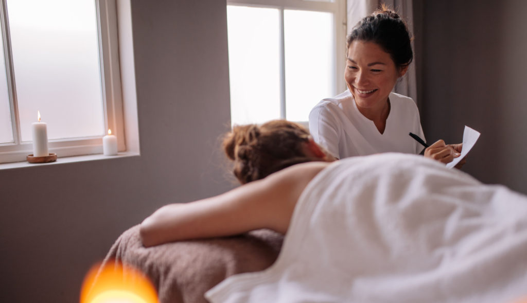 massage therapist giving massage with candles hero