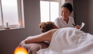 massage therapist giving massage with candles hero