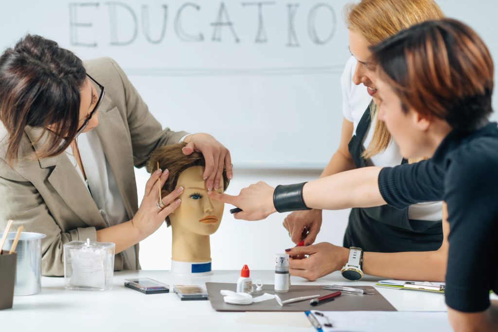 cosmetologists gathered around learning techniques