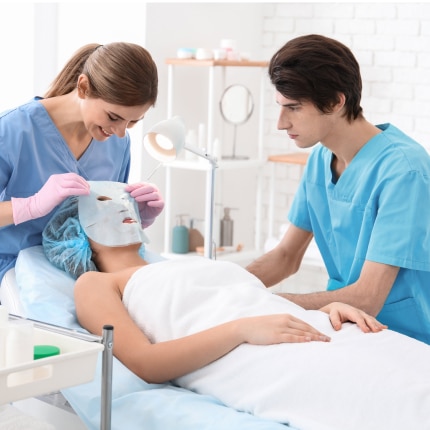 esthetician students putting face mask on client