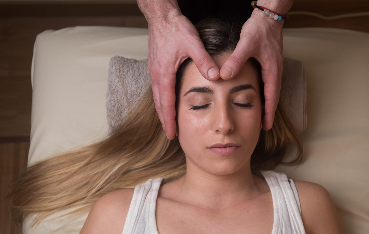 close up image of woman with hands on forehead reiki