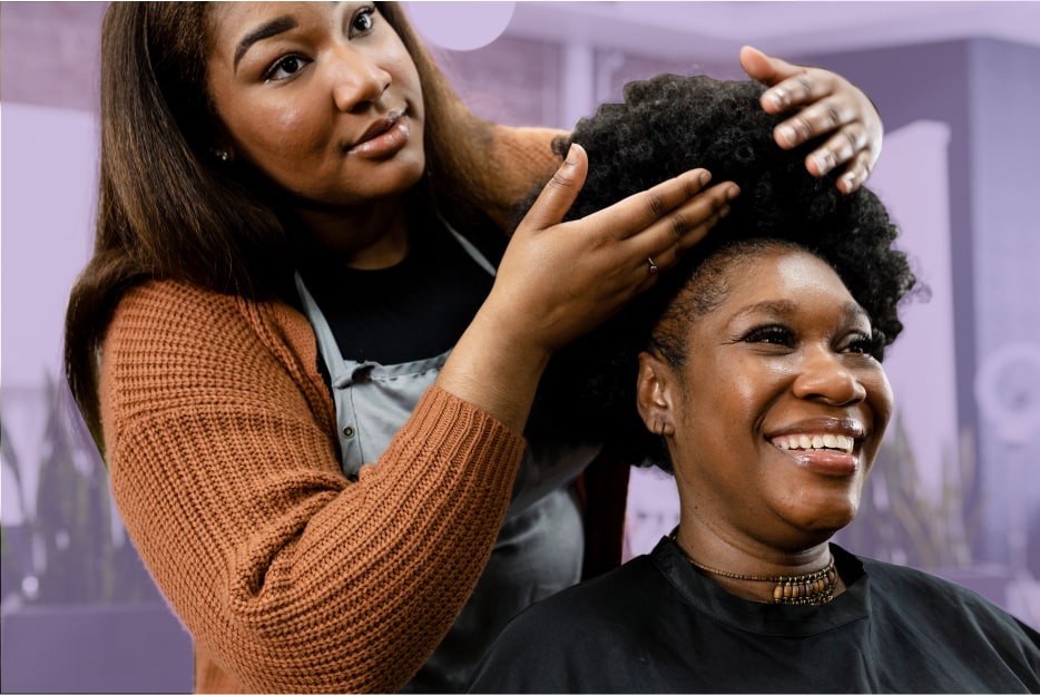 hair stylist fixing clients hair with a smile