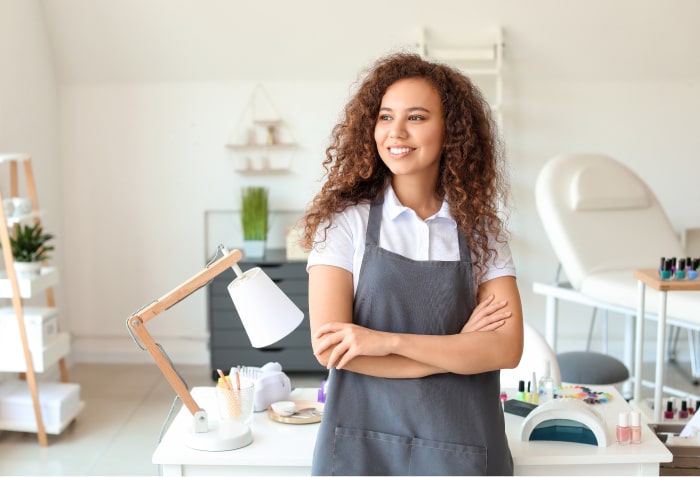 nail tech looking pleased looking to side of screen