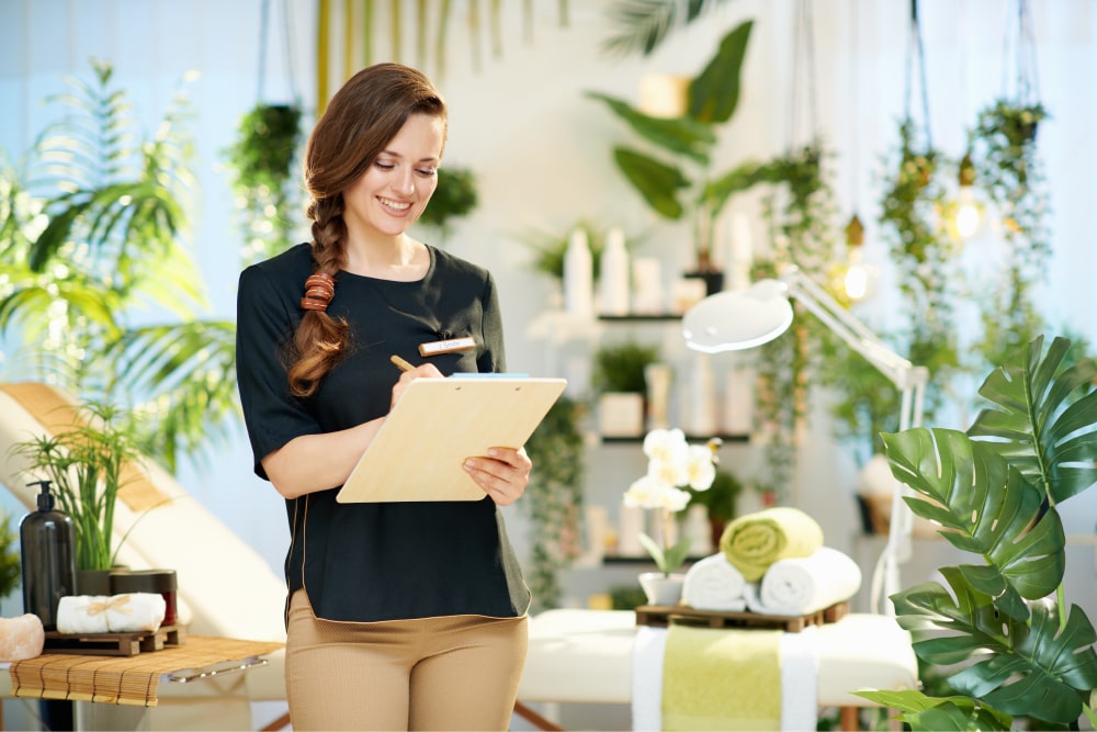 Woman smiles while writing on clipboard in beauty salon