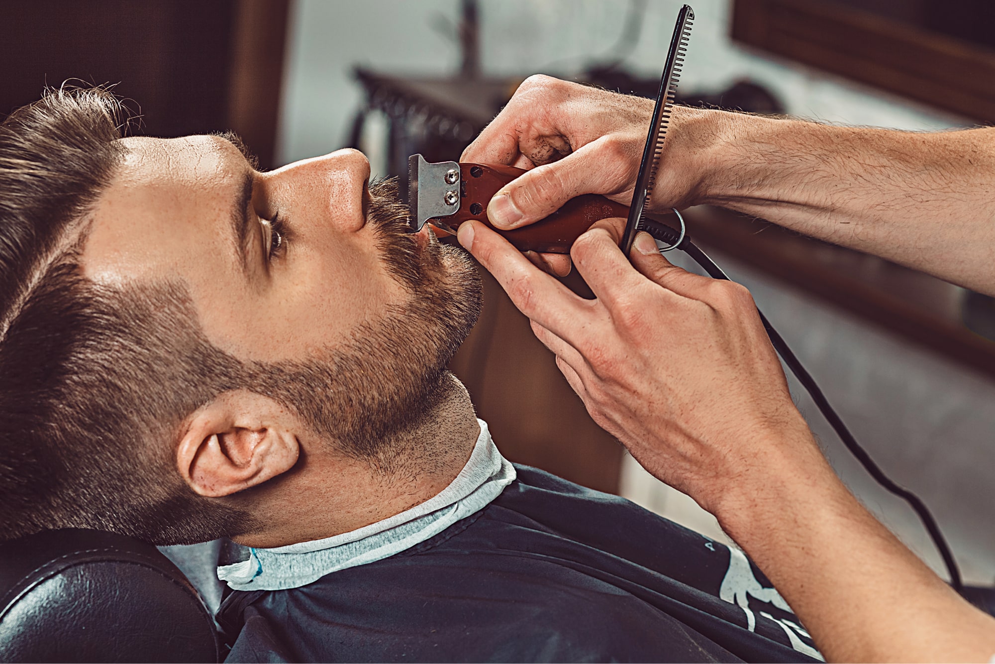 close up of man getting beard groomed at barbers