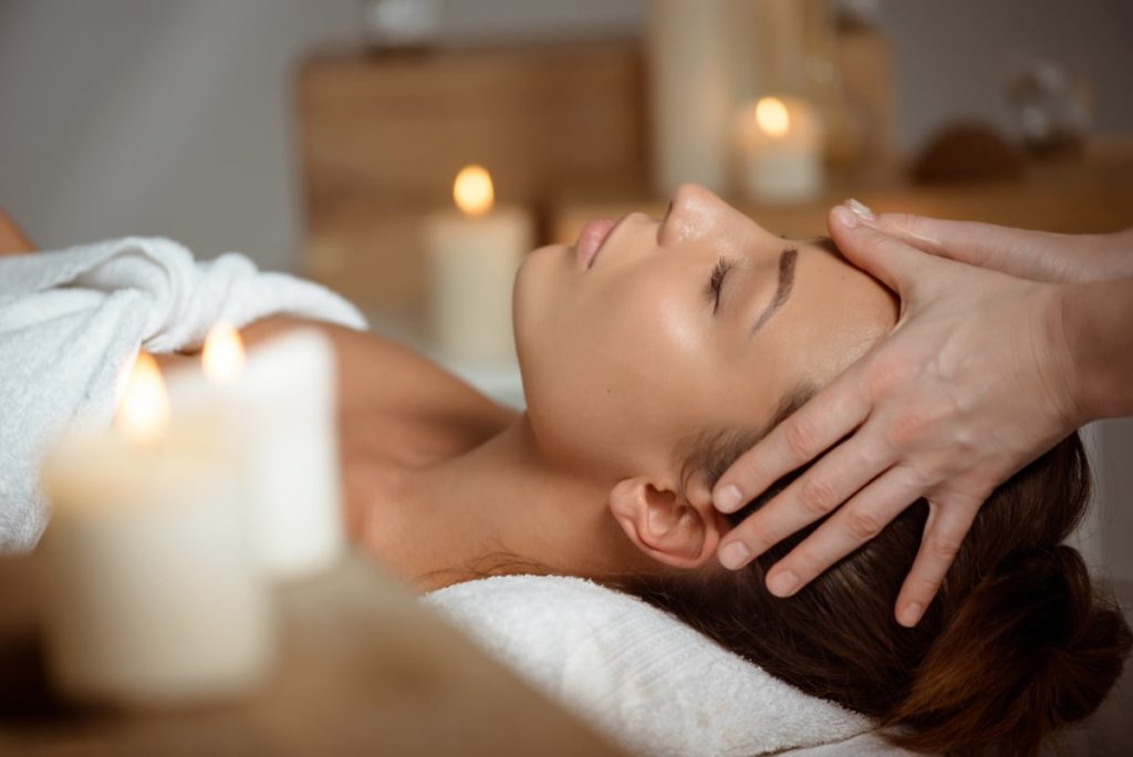 Image of woman in spa receiving scalp massage