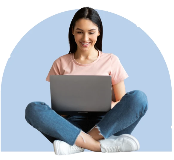 girl sitting crossed-legged while on her computer smiling
