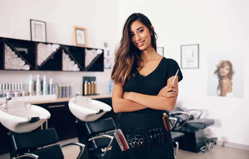 hairstylist posing in front of salon chairs