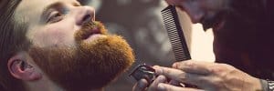 barber trimming mans beard