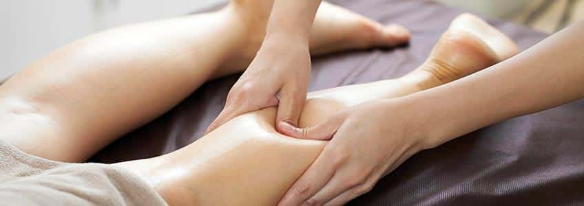sports massage therapist massaging clients calf