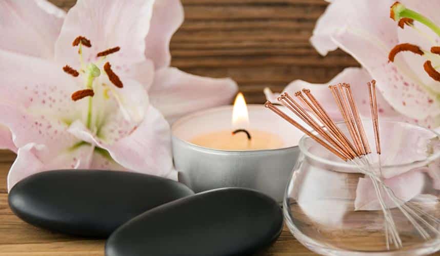 acupuncture needles and massage stones at a spa