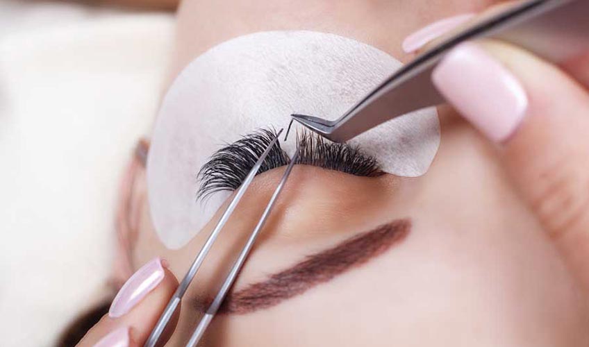 esthetician placing false eyelashes