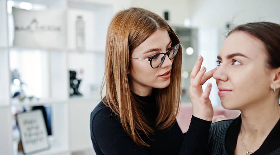 esthetician applying under eye cream on client