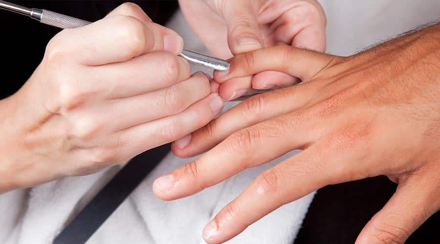 man getting coticules trimmed during manicure