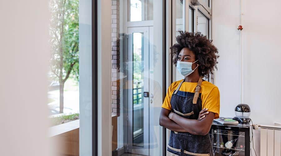beauty professional standing with arms crossed gazing out window
