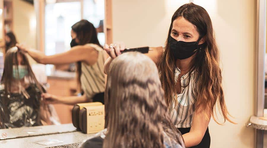 beauty professional combing clients hair at a salon