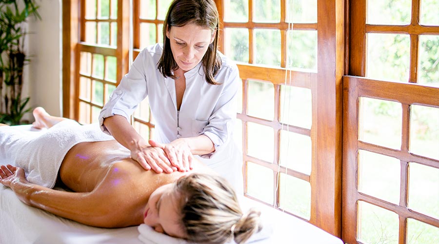 massage therapist carefully massaging woman's back