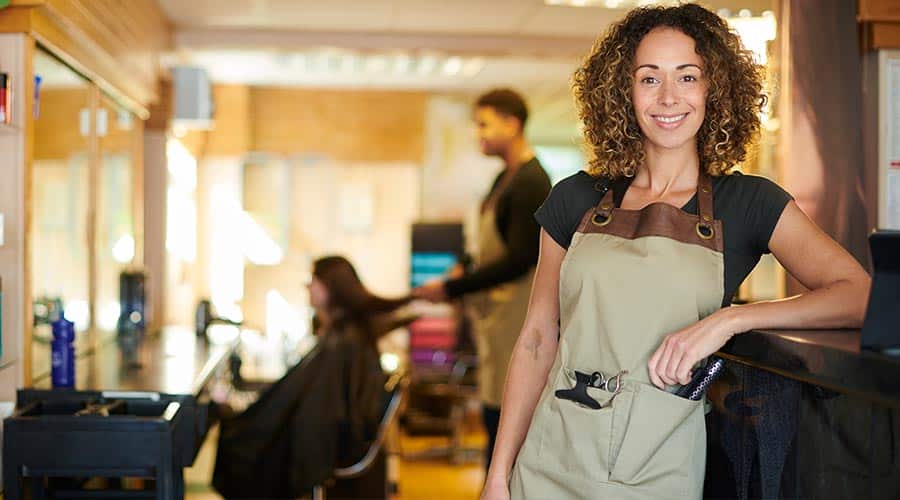 beauty professional posing in front of mobile hair salon