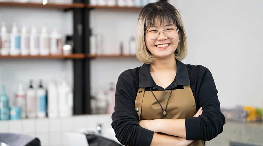 salon owner posing in front of products in salon