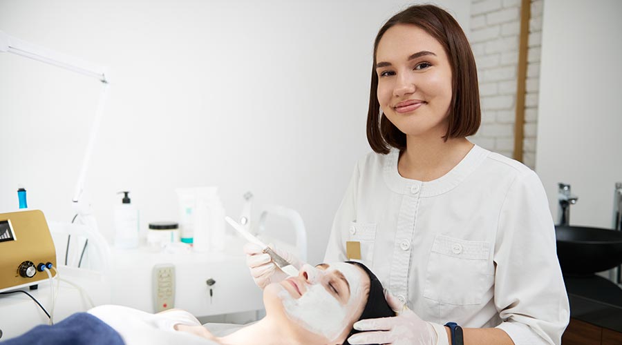 esthetician applying white mask to clients face