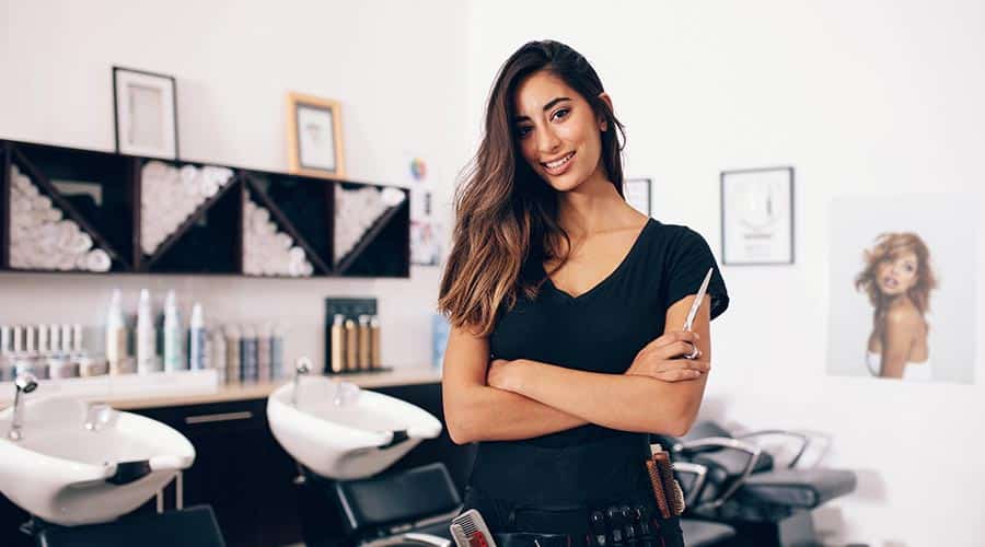 hair stylist standing in front of empty salon chairs