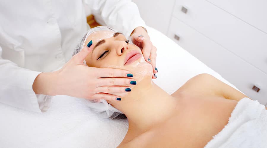 woman getting a facial treatment from esthetician