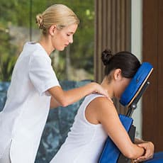 massage therapist giving a chair massage to client