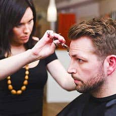 hairstylist trimming mans hair