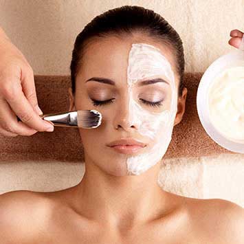 esthetician applying face mask with brush