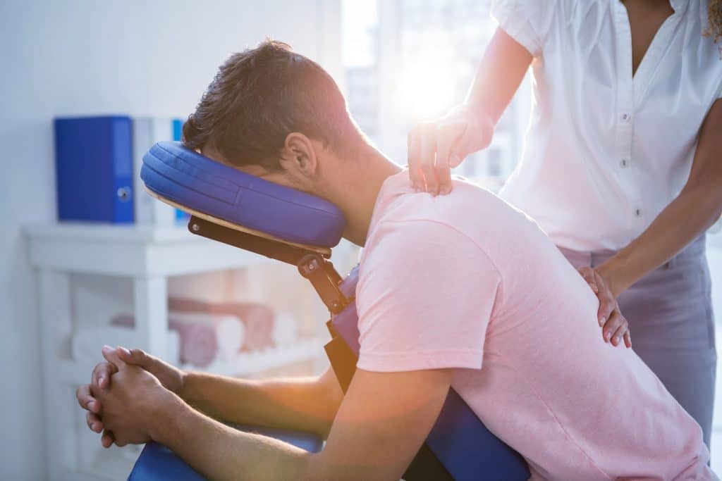 massage therapist with client in forward position