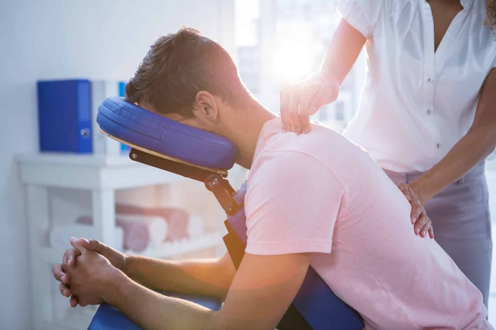 massage therapist with client in forward position