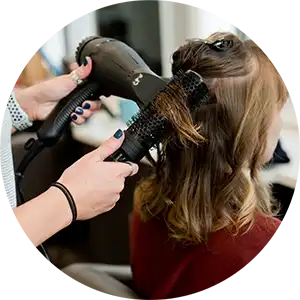 hair stylist blow drying clients hair