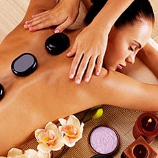 woman laying on stomach getting hot stone massage