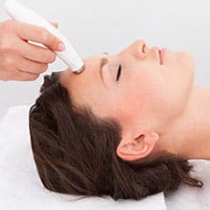 woman getting a microdermabrasion treatment on her forehead
