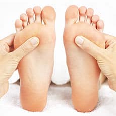 performing reflexology on feet