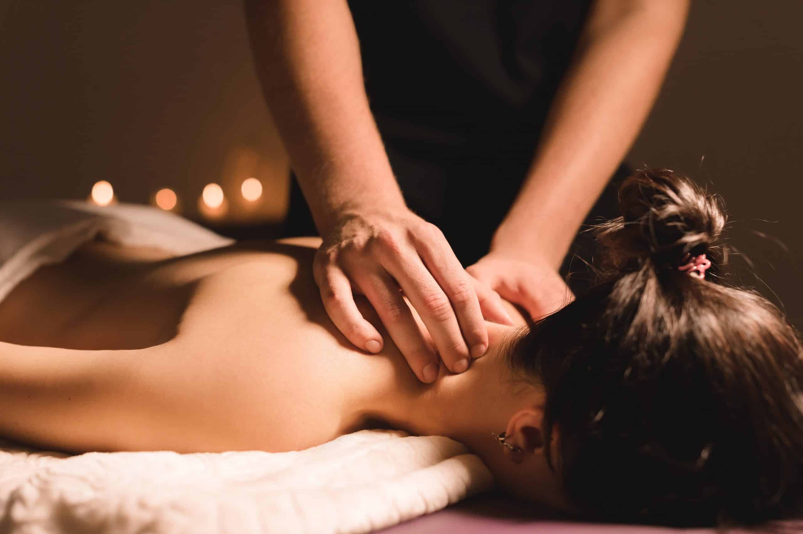 massage therapist giving massage with candles